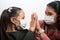 Mother and daughter wear medical masks and clasp hands in hopes that everything will pass. Coronavirus infection concept Covid-19