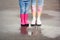 Mother and daughter wearing rubber boots on street