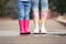 Mother and daughter wearing rubber boots on street