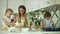 Mother With Daughters Cooking Food In Modern Light Kitchen