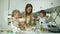 Mother With Daughters Cooking Food In Modern Light Kitchen