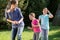 Mother with daughters doing dance exercise outdoors