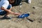 Mother and daughters in gloves cleaning up the beach. Group of young volunteers helping to keep nature clean and picking up the