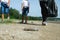 Mother and daughters in gloves cleaning up the beach. Group of young volunteers helping to keep nature clean and picking up the