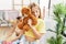 Mother and daughters holding soft teddy bear washing clothes at laundry room