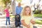 Mother And Daughters Picking Up Litter In Suburban Street