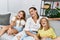 Mother and daughters smiling confident sitting on sofa at home