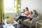 Mother and daughters on sofa at home listening TV