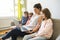 Mother and daughters on sofa at home using laptop