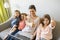 Mother and daughters on sofa at home using laptop