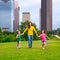 Mother and daughters walking holding hands on city skyline