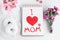 Mother day greeting card on white background. Breakfast, carnation gift and a postcard made by the child for mom.