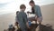 Mother Digging With Children on the Beach