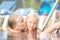 Mother embraces daughter near ladder in pool in tropical beach r