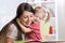 Mother embracing and reading a book to kid at home