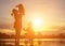 Mother encouraged her son outdoors at sunset, silhouette concept