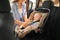 Mother fastening baby to child safety seat