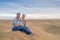 Mother, father and 2 years old boy sitting on top of the sand dune, Sahara Desert