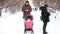 Mother and father addicted to mobile phones neglecting baby in stroller and while walking in winter park. Parents busy