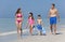 Mother, Father & Children Family Walking on Beach