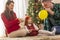 Mother, father and daughter blowing balloons for Christmas