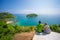 Mother, father and daughter embraces and sit on tropical island