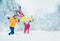 Mother and father family fooling in snow forest by throwing their little daugher to snowdrift