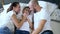 Mother and father kisses the son on bed closeup indoors, lovely family moments