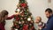 Mother, father and little baby decorated christmas tree. Man holding child near fir tree, showing bright decoration