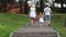 Mother, father, little daughter walk in summer park, back view