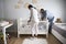 Mother And Father Looking At Baby Daughter In Nursery Cot