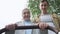 Mother and father push stroller together walking in park