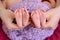 Mother and father`s hands cradling twin babies feet