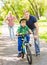 Mother and father teaches his son to ride a bike