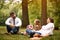 Mother and father with their daughter after work and school sitting and resting at park