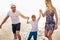 Mother and father with their son walking on a quiet beach