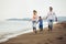 Mother and father with their son walking together on the beach