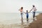 Mother and father with their son walking together on the beach