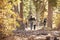 Mother, father and two children hiking in forest, back view