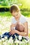 Mother feeding her baby in nature green meadow with white flower