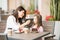 Mother feeding her daughter with cake at the cafe