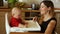 Mother feeding hungry baby in highchair in kitchen. The woman gently smiles at the baby. Mothers Day