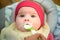 Mother feeding hungry five month old baby with spoon, solid food. Newborn feeding concept