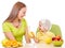 Mother feeding little girl with healthy food sitting at table