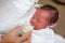 Mother feeding milk infant baby by glass cup