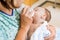 Mother Feeding Milk To Newborn Baby Girl In