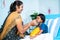 Mother feeding porridge to ill kid while admitted at hospital ward - concept of parental caring, medical treatment and