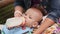 Mother feeds baby from a bottle in his lap. Close-up.
