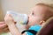 Mother feeds baby from a bottle of milk