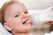 Mother feeds baby from a bottle of milk